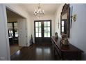 Elegant foyer featuring hardwood floors, chandelier lighting, decorative mirror, and double entry doors at 615 Sampson St, Raleigh, NC 27609