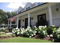Inviting front porch with classic white columns, black railings, and lush hydrangeas enhancing curb appeal at 615 Sampson St, Raleigh, NC 27609