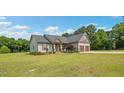 An eye-level view of the exterior of the home featuring a two-car garage and manicured lawn at 7055 Nc-242, Dunn, NC 28334