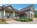 Inviting front porch featuring stone accents, well-kept landscaping, and seating area at 7055 Nc-242, Dunn, NC 28334
