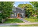 Beautiful two-story home with a gray exterior, manicured lawn, and mature shade trees at 924 W Trinity Ave, Durham, NC 27701