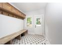 Bright mudroom features a bench with hooks and a starburst patterned floor at 924 W Trinity Ave, Durham, NC 27701
