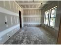 Unfinished living room showcasing large windows, a door, and unfinished walls at 1025 Coldspring Circle, Durham, NC 27705