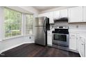 Bright kitchen featuring stainless steel appliances and dark wood flooring at 105 Sir Richard Ln, Chapel Hill, NC 27517