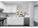 Bright kitchen with white cabinets, stainless steel appliances and a view to the Gathering room at 105 Sir Richard Ln, Chapel Hill, NC 27517