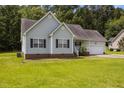 Charming single-story home featuring a manicured lawn, and lush landscaping at 106 Oak Rd, Butner, NC 27509