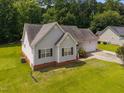 Charming single-story home featuring a manicured lawn, and lush landscaping at 106 Oak Rd, Butner, NC 27509