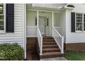 Inviting front porch with brick steps and white railing, offering a warm welcome at 1112 Newberry Dr, Mebane, NC 27302