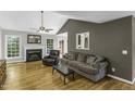Cozy living room featuring hardwood floors, a fireplace, and a ceiling fan at 1112 Newberry Dr, Mebane, NC 27302