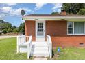 Close-up of the home's entrance featuring a white door, stairs, and a vibrant red brick facade at 1209 Bobbitt Dr, Garner, NC 27529