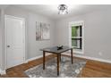Bright dining area featuring hardwood floors, stylish rug, modern light fixture, and glass top table near window at 123 Becket Bend Bnd, Pittsboro, NC 27312