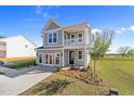 Inviting two-story home boasts a charming balcony and fresh landscaping, set against a sunny sky at 1305 Westerland Way # 17, Durham, NC 27703