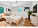 Bright bedroom featuring a ceiling fan, wood floors, and natural light from the windows at 1311 Meadow Ln, Chapel Hill, NC 27516