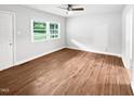 Bedroom featuring hardwood floors, a ceiling fan and natural light from large windows at 1311 Meadow Ln, Chapel Hill, NC 27516