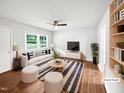 Bright, staged living room with wood floors, comfortable seating, and ample natural light at 1311 Meadow Ln, Chapel Hill, NC 27516