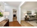 Bright foyer with hardwood floors leading into a cozy living room featuring a fireplace and comfortable seating at 1416 Bramble Dr, Durham, NC 27712