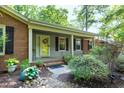 Inviting front porch with a bright yellow door, fresh landscaping and black shutters, enhancing the home's curb appeal at 1416 Bramble Dr, Durham, NC 27712
