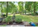 A lush lawn surrounded by mature trees, offering a private and serene outdoor space perfect for relaxation at 1416 Bramble Dr, Durham, NC 27712
