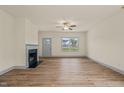 Bright living room featuring a fireplace, ceiling fan, a large window, and wood flooring at 147 Harmony Trl, Broadway, NC 27505