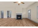 Spacious living room with fireplace, ceiling fan, and luxury vinyl plank flooring at 147 Harmony Trl, Broadway, NC 27505