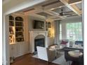 Comfortable living room featuring a fireplace, built-in shelving, hardwood floors and a ceiling fan at 1512 Obrien Cir, Wake Forest, NC 27587