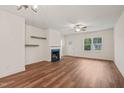 Spacious living room featuring a fireplace, ceiling fan, and warm, inviting hardwood floors at 156 Harmony Trl, Broadway, NC 27505