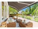 Spacious outdoor deck featuring comfortable wicker seating, a retractable awning, and serene backyard views at 1901 White Oak Rd, Raleigh, NC 27608