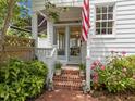 Inviting front porch with brick steps, potted plants, and an American flag creating a warm welcome at 1901 White Oak Rd, Raleigh, NC 27608