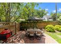 Outdoor patio with brick flooring, a dining table set, grill, and a fenced backyard for private enjoyment at 1901 White Oak Rd, Raleigh, NC 27608