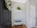 Cozy entryway with a decorative wreath, coat rack, and bench, creating a welcoming first impression at 2021 Rivergate Rd # 102, Raleigh, NC 27614