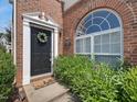 Inviting entryway featuring a decorative wreath, black door, and arched window for natural light at 2021 Rivergate Rd # 102, Raleigh, NC 27614
