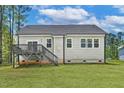 A spacious backyard with a deck and stairs leads to the house, showcasing the rear exterior at 205 Shawnee Dr, Louisburg, NC 27549