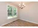 Bright dining room with hardwood floors, large window, and modern chandelier at 213 Clement Ave, Oxford, NC 27565