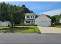 Charming two-story home with attached garage and well-maintained landscaping at 216 Edgecombe Dr, Spring Lake, NC 28390