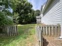 Large backyard with a wooden fence, grassy area, and mature trees providing shade and privacy at 2208 Fieldmont Ct, Raleigh, NC 27614
