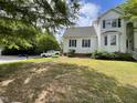 Side view of a two-story home featuring green shutters and a lush green lawn and driveway at 2208 Fieldmont Ct, Raleigh, NC 27614