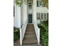 Inviting front entrance with brick steps, white railings, and a dark green front door at 2208 Fieldmont Ct, Raleigh, NC 27614