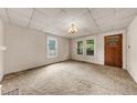 Spacious carpeted living room features multiple windows for natural light at 2631 Harvard Ave, Durham, NC 27703