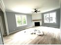 Bright living room features hardwood floors, a ceiling fan, and a modern fireplace at 2651 Bowden Dr, Creedmoor, NC 27522