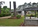 Landscaped front yard featuring mature trees, flowering plants, and a decorative well structure at 3610 Lambert Ln, Rocky Mount, NC 27804