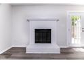 Bright living room featuring sleek floors and a cozy white brick fireplace at 404 Shannonford Ct, Wake Forest, NC 27587