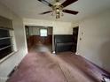 Living room with stained carpet and a piano visible at 603 Pineland St, Sanford, NC 27330