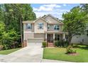 Charming two-story home featuring tan siding, brick accents, a well-manicured lawn, and an attached two-car garage at 724 Piermont Dr, Cary, NC 27519