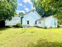 Rear view of home featuring original siding, roof, and a spacious green lawn at 747 Buckhorn Rd, Sanford, NC 27330