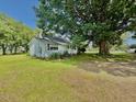 Side view of a farmhouse with mature shade trees and a well maintained lawn at 747 Buckhorn Rd, Sanford, NC 27330