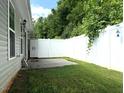 A cozy backyard area featuring a concrete patio and a white privacy fence at 820 Houston Ct, Haw River, NC 27258