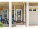 Charming front porch with rocking chairs, leading to the inviting front door and attached garage at 100 Beaconwood Ln, Holly Springs, NC 27540