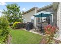 Outdoor patio area with seating, a grill, and a view of the well-maintained backyard at 100 Beaconwood Ln, Holly Springs, NC 27540