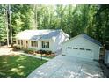 Aerial view of a single-story home with a detached garage, long driveway, and a lush green lawn at 1006 Oxford Ridge Rd, Wake Forest, NC 27587