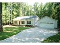 Single-story home featuring a detached garage, long driveway, and well-maintained landscaping at 1006 Oxford Ridge Rd, Wake Forest, NC 27587